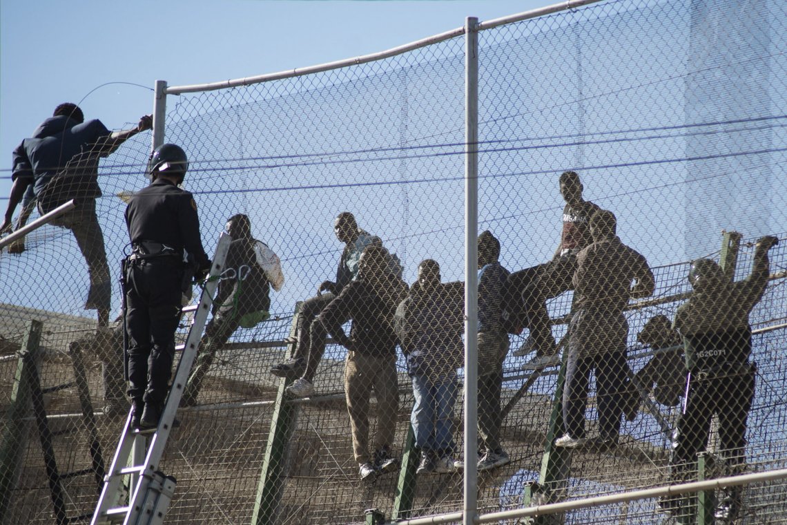 African migrants sit on top of a border fence during an attempt to cross into Spanish territories, between Morocco and Spain's north African enclave of Melilla, November 21, 2015. REUTERS/Jesus Blasco de Avellaneda African migrants sit on top of a border fence during an attempt to cross into Spanish territories, between Morocco and Spain's north African enclave of Melilla, November 21, 2015. REUTERS/Jesus Blasco de Avellaneda