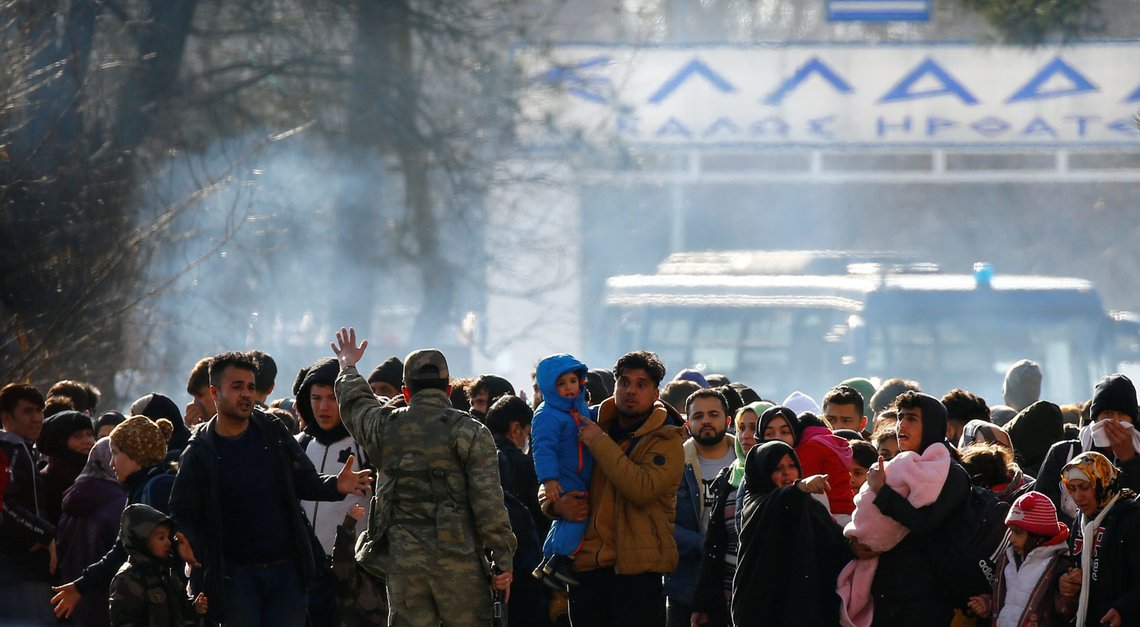 A picture taken from Pazarkule shows a group of migrants waiting on no man's land between Turkey and Greece, at the Turkeys Pazarkule border crossing with Greece's Kastanies, in Turkey, February 28, 2020. REUTERS/Huseyin Aldemir A picture taken from Pazarkule shows a group of migrants waiting on no man's land between Turkey and Greece, at the Turkeys Pazarkule border crossing with Greece's Kastanies, in Turkey, February 28, 2020. REUTERS/Huseyin Aldemir