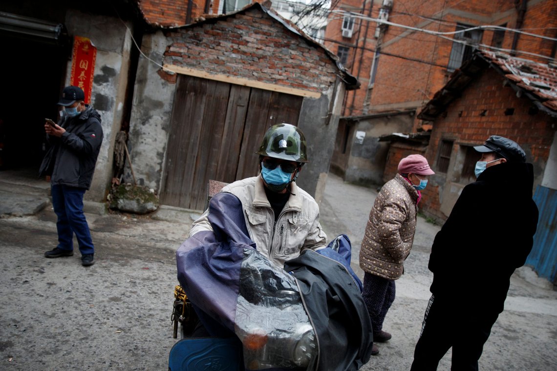 People wear masks in an old neighbourhood in Jiujiang, Jiangxi province, China, as the country is hit by an outbreak of the novel corona virus, February 2, 2020. REUTERS/Thomas Peter People wear masks in an old neighbourhood in Jiujiang, Jiangxi province, China, as the country is hit by an outbreak of the novel corona virus, February 2, 2020. REUTERS/Thomas Peter