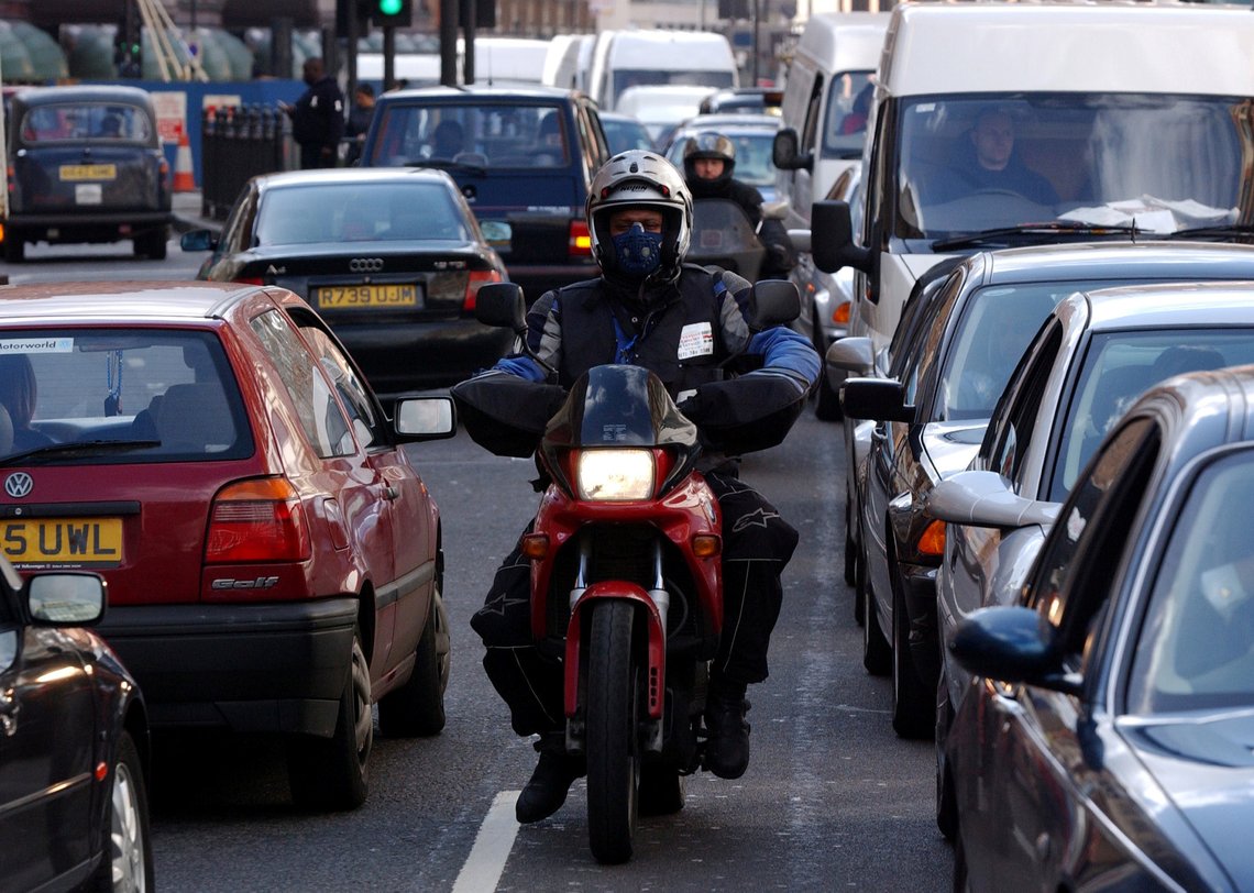 FILE PHOTO: A motorcyclist makes his way through a traffic jam in central London, February 26, 2002. REUTERS/Stephen Hird/File Photo FILE PHOTO: A motorcyclist makes his way through a traffic jam in central London, February 26, 2002. REUTERS/Stephen Hird/File Photo