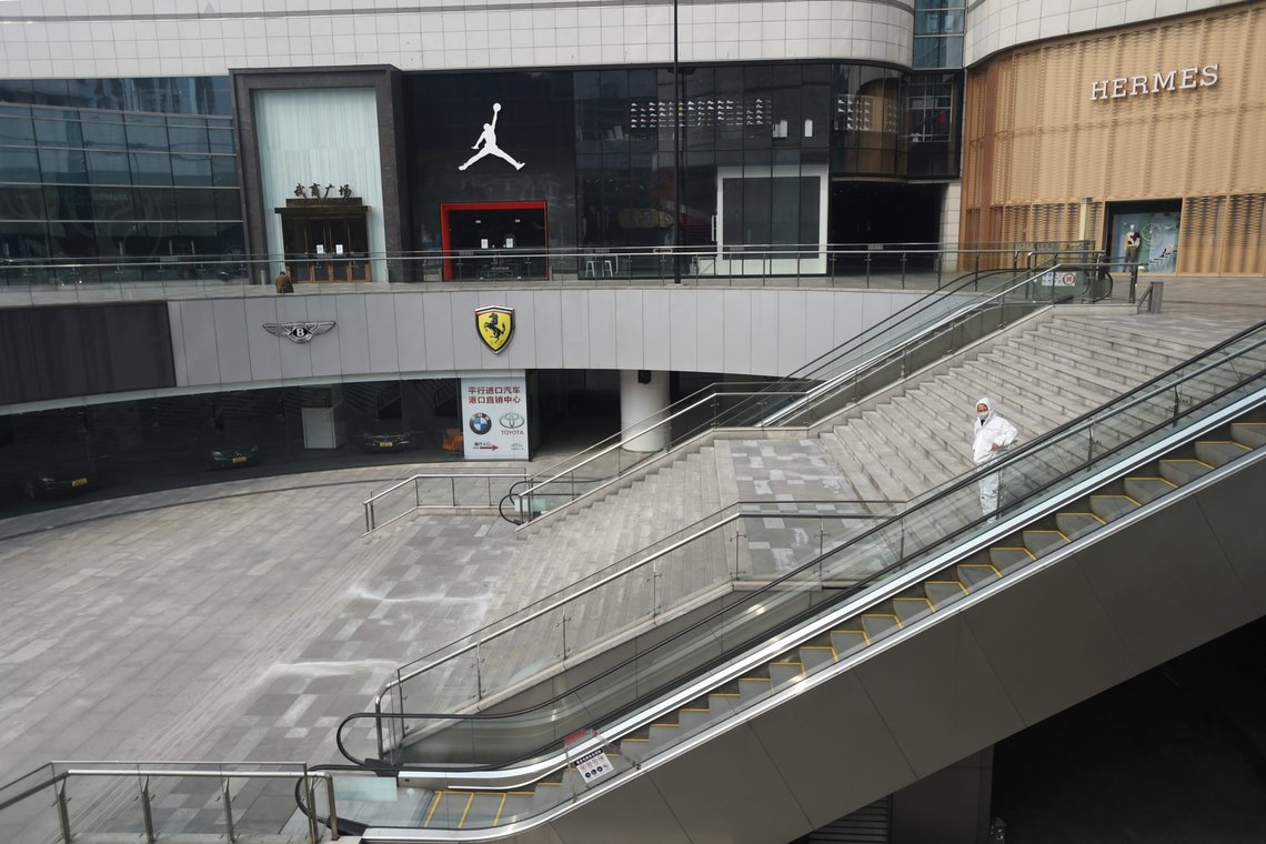A man in protective suit stands at a shopping mall in Wuhan, the epicentre of the novel coronavirus outbreak, Hubei province, China February 25, 2020. REUTERS/Stringer CHINA OUT. A man in protective suit stands at a shopping mall in Wuhan, the epicentre of the novel coronavirus outbreak, Hubei province, China February 25, 2020. REUTERS/Stringer CHINA OUT.