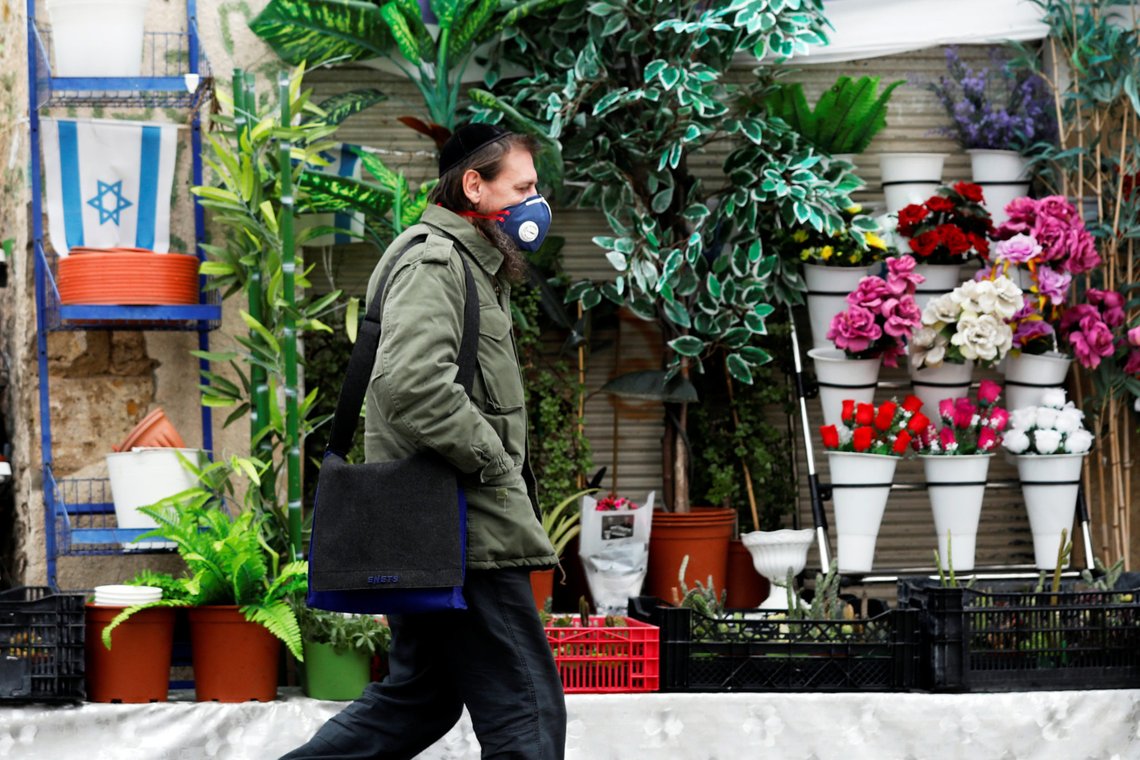 A man wears a face mask as he walks in a market in Ashkelon while Israel tightened a national stay-at-home policy following the spread of coronavirus disease (COVID-19) in Ashkelon, Israel March 20, 2020. REUTERS/Amir Cohen A man wears a face mask as he walks in a market in Ashkelon while Israel tightened a national stay-at-home policy following the spread of coronavirus disease (COVID-19) in Ashkelon, Israel March 20, 2020. REUTERS/Amir Cohen