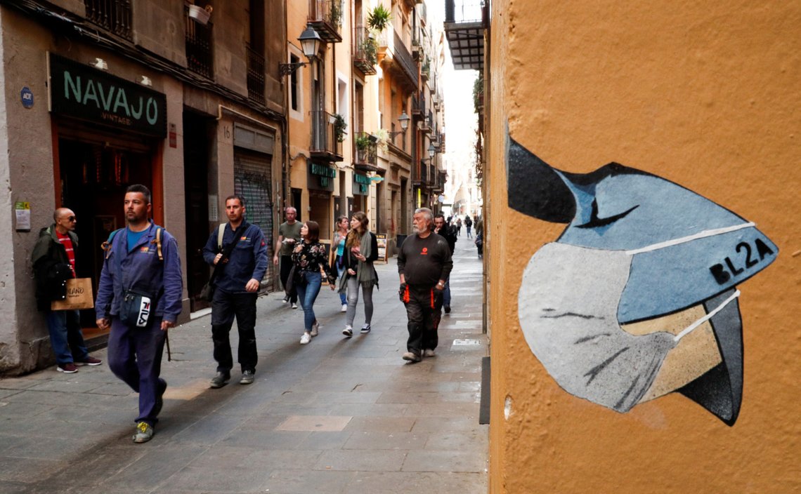 People pass near a drawing of a person wearing a mask in a wall, due to the coronavirus outbreak, in central Barcelona, Spain, March 12, 2020. REUTERS/Albert Gea People pass near a drawing of a person wearing a mask in a wall, due to the coronavirus outbreak, in central Barcelona, Spain, March 12, 2020. REUTERS/Albert Gea
