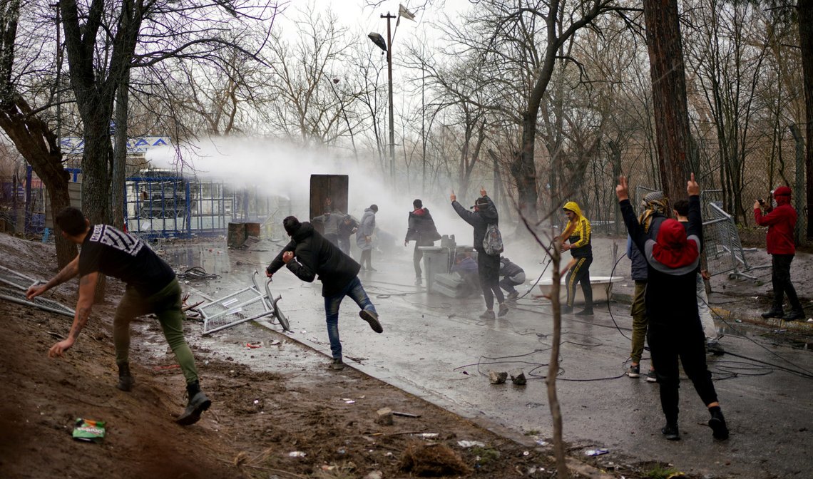 Greek riot police use a water cannon to disperse stone throwing migrants as they wait on the no man's land between Turkey and Greece, at Turkey's Pazarkule border crossing with Greece's Kastanies, in Edirne, Turkey, March 8, 2020. Ismail Coskun/Ihlas News Agency (IHA) via REUTERS ATTENTION EDITORS - THIS PICTURE WAS PROVIDED BY A THIRD PARTY. NO RESALES. NO ARCHIVE. TURKEY OUT. NO COMMERCIAL OR EDITORIAL SALES IN TURKEY. Greek riot police use a water cannon to disperse stone throwing migrants as they wait on the no man's land between Turkey and Greece, at Turkey's Pazarkule border crossing with Greece's Kastanies, in Edirne, Turkey, March 8, 2020. Ismail Coskun/Ihlas News Agency (IHA) via REUTERS ATTENTION EDITORS - THIS PICTURE WAS PROVIDED BY A THIRD PARTY. NO RESALES. NO ARCHIVE. TURKEY OUT. NO COMMERCIAL OR EDITORIAL SALES IN TURKEY.