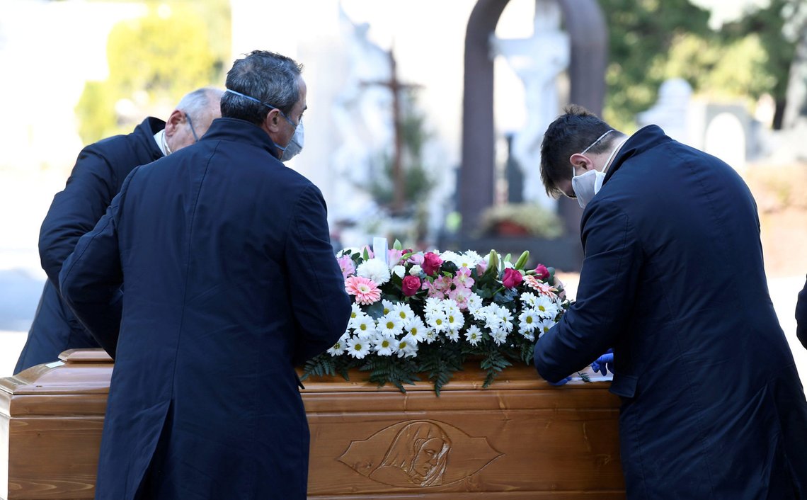 FILE PHOTO: Cemetery workers and funeral agency workers in protective masks transport a coffin of a person who died from coronavirus disease (COVID-19), into a cemetery in Bergamo, Italy March 16, 2020. REUTERS/Flavio Lo Scalzo/File Photo FILE PHOTO: Cemetery workers and funeral agency workers in protective masks transport a coffin of a person who died from coronavirus disease (COVID-19), into a cemetery in Bergamo, Italy March 16, 2020. REUTERS/Flavio Lo Scalzo/File Photo