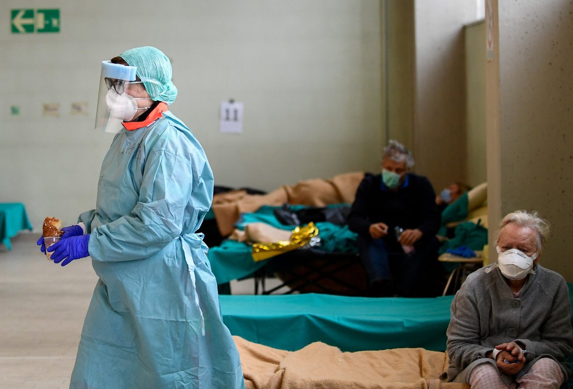 FILE PHOTO: Medical personnel wearing protective face masks helps patients inside the Spedali Civili hospital in Brescia, Italy March 13, 2020. REUTERS/Flavio Lo Scalzo/File Photo FILE PHOTO: Medical personnel wearing protective face masks helps patients inside the Spedali Civili hospital in Brescia, Italy March 13, 2020. REUTERS/Flavio Lo Scalzo/File Photo