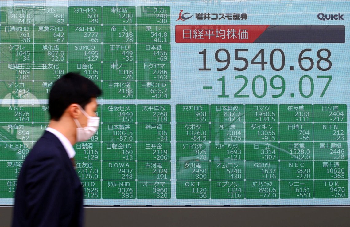 A passerby wearing a protective face mask following an outbreak of the coronavirus disease (COVID-19), walks past an electronic display showing Asian markets indices outside a brokerage in Tokyo, Japan, March 9, 2020. REUTERS/Edgard Garrido A passerby wearing a protective face mask following an outbreak of the coronavirus disease (COVID-19), walks past an electronic display showing Asian markets indices outside a brokerage in Tokyo, Japan, March 9, 2020. REUTERS/Edgard Garrido