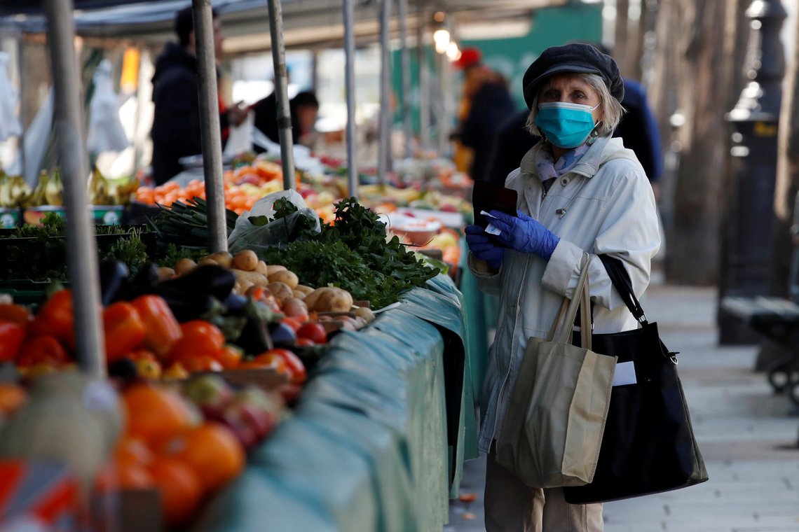 FILE PHOTO: A woman, wearing a protective face mask, shops for fruits and vegetables at the Bastille Market in Paris as a lockdown is imposed to slow the rate of the coronavirus disease (COVID-19) in France, March 19, 2020. REUTERS/Gonzalo Fuentes/File Photo FILE PHOTO: A woman, wearing a protective face mask, shops for fruits and vegetables at the Bastille Market in Paris as a lockdown is imposed to slow the rate of the coronavirus disease (COVID-19) in France, March 19, 2020. REUTERS/Gonzalo Fuentes/File Photo