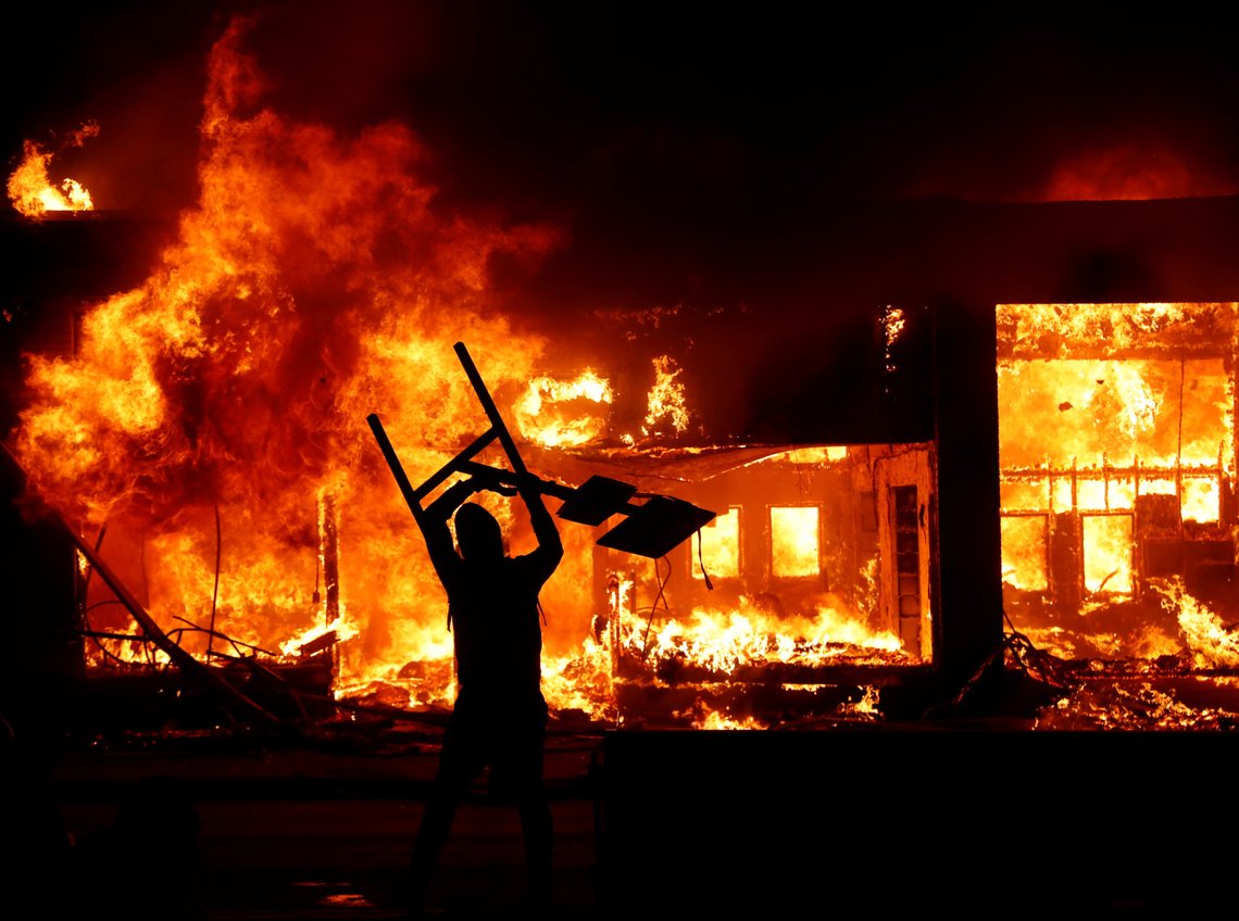 A protester holds an object in front of a fire during a demonstration against the death in Minneapolis police custody of African-American man George Floyd, in Minneapolis, Minnesota, U.S., early May 30, 2020. REUTERS/Lucas Jackson A protester holds an object in front of a fire during a demonstration against the death in Minneapolis police custody of African-American man George Floyd, in Minneapolis, Minnesota, U.S., early May 30, 2020. REUTERS/Lucas Jackson