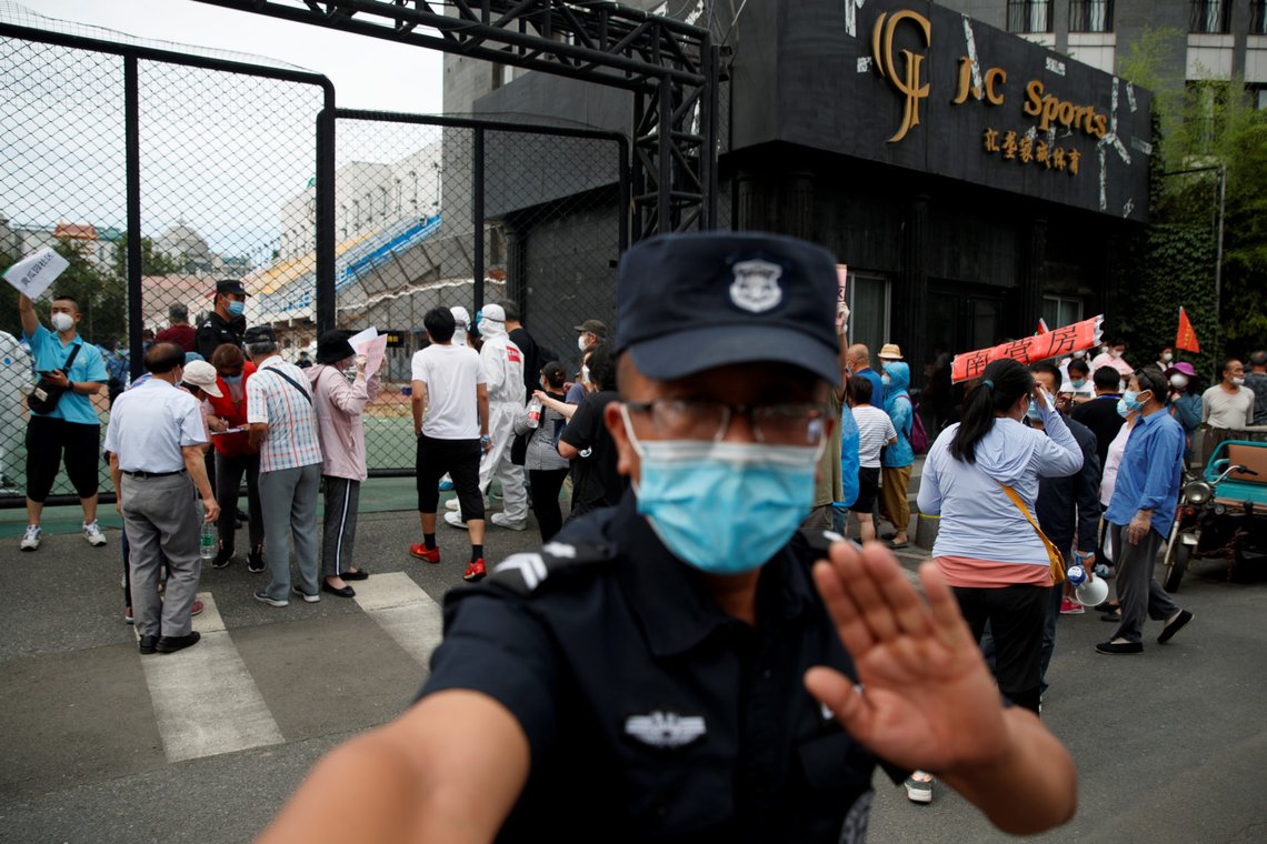A security guard gestures at the photographer as people crowd outside the Guangan Sport Center to get tested after an unexpected spike of cases of the coronavirus disease (COVID-19) in Beijing, China June 15, 2020. REUTERS/Thomas Peter A security guard gestures at the photographer as people crowd outside the Guangan Sport Center to get tested after an unexpected spike of cases of the coronavirus disease (COVID-19) in Beijing, China June 15, 2020. REUTERS/Thomas Peter