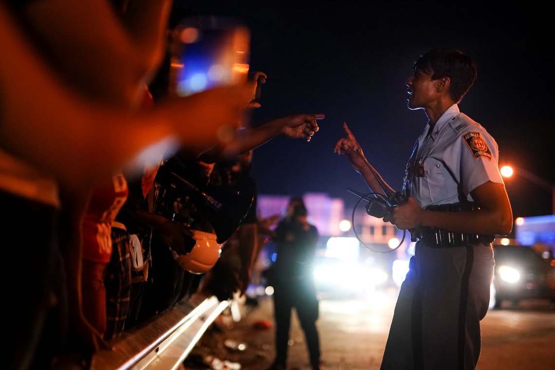 Protesters film an interaction with a Georgia State Patrol officer during a rally against racial inequality and the police shooting death of Rayshard Brooks, in Atlanta, Georgia, U.S. June 13, 2020. REUTERS/Elijah Nouvelage Protesters film an interaction with a Georgia State Patrol officer during a rally against racial inequality and the police shooting death of Rayshard Brooks, in Atlanta, Georgia, U.S. June 13, 2020. REUTERS/Elijah Nouvelage
