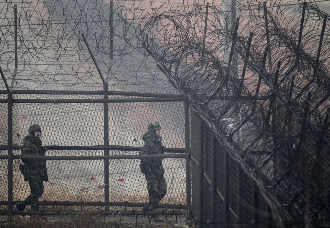 South Korean soldiers walk along barbed wire fence as they move to their guard post near the Demilitarized Zone (DMZ) separating the two Koreas in Paju, about 52 km (32 miles) north of Seoul, December 1, 2010. South Korea plans more military drills after U.S. warships leave on Wednesday, Yonhap news agency said, a move likely to add to tension on the divided peninsula after last week's attack by the North. REUTERS/Kim Kyung-Hoon (SOUTH KOREA - Tags: POLITICS MILITARY) South Korean soldiers walk along barbed wire fence as they move to their guard post near the Demilitarized Zone (DMZ) separating the two Koreas in Paju, about 52 km (32 miles) north of Seoul, December 1, 2010. South Korea plans more military drills after U.S. warships leave on Wednesday, Yonhap news agency said, a move likely to add to tension on the divided peninsula after last week's attack by the North. REUTERS/Kim Kyung-Hoon (SOUTH KOREA - Tags: POLITICS MILITARY)