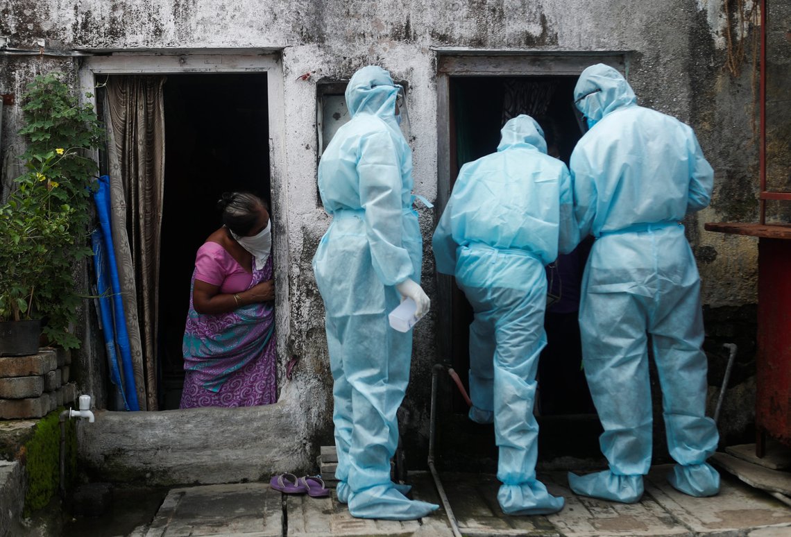 A woman watches as healthcare workers wearing personal protective equipment (PPE) check the temperature of residents of a slum during a check-up camp for the coronavirus disease (COVID-19) in Mumbai, India June 17, 2020. REUTERS/Francis Mascarenhas A woman watches as healthcare workers wearing personal protective equipment (PPE) check the temperature of residents of a slum during a check-up camp for the coronavirus disease (COVID-19) in Mumbai, India June 17, 2020. REUTERS/Francis Mascarenhas