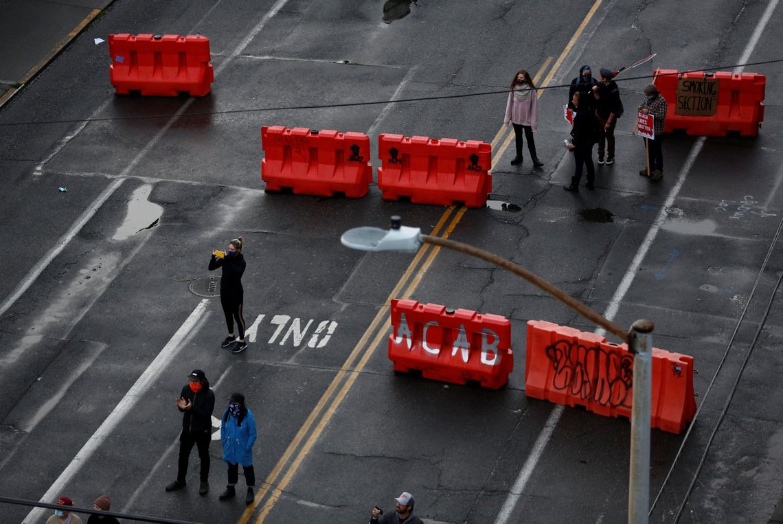 People stand near barricades formerly used to keep them out of the area, as the protesters established what they call an autonomous zone while continuing to demonstrate against racial inequality and call for defunding of Seattle police, in Seattle, Washington, U.S. June 9, 2020. Picture taken June 9, 2020. REUTERS/Lindsey Wasson People stand near barricades formerly used to keep them out of the area, as the protesters established what they call an autonomous zone while continuing to demonstrate against racial inequality and call for defunding of Seattle police, in Seattle, Washington, U.S. June 9, 2020. Picture taken June 9, 2020. REUTERS/Lindsey Wasson