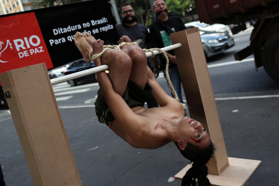 A member of NGO Rio de Paz (Rio of Peace) simulates the method of torture known as "pau-de-arara" as a protest against the 55th anniversary of Brazil's 1964 military coup in Sao Paulo, Brazil April 1, 2019. The banner reads "Dictatorship in Brazil: So that it does not repeat itself." REUTERS/Amanda Perobelli A member of NGO Rio de Paz (Rio of Peace) simulates the method of torture known as "pau-de-arara" as a protest against the 55th anniversary of Brazil's 1964 military coup in Sao Paulo, Brazil April 1, 2019. The banner reads "Dictatorship in Brazil: So that it does not repeat itself." REUTERS/Amanda Perobelli