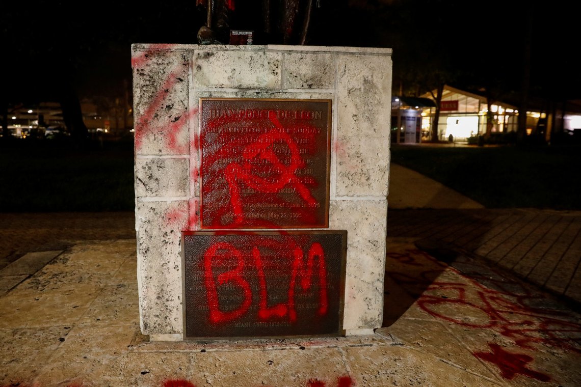 Graffiti is seen on a vandalized statue of Christopher Columbus at the Bayside Marketplace, after a protest against racial inequality in the aftermath of the death in Minneapolis police custody of George Floyd, in Downtown Miami, Florida, U.S., June 10, 2020. REUTERS/Marco Bello Graffiti is seen on a vandalized statue of Christopher Columbus at the Bayside Marketplace, after a protest against racial inequality in the aftermath of the death in Minneapolis police custody of George Floyd, in Downtown Miami, Florida, U.S., June 10, 2020. REUTERS/Marco Bello