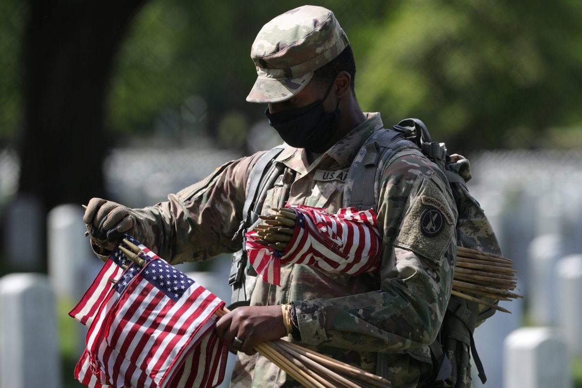 A U.S. Army Old Guard member holds small American flags to put in front of the headstones of U.S. service members buried at Arlington National Cemetery in Arlington, Virginia, U.S., May 21, 2020. REUTERS/Tom Brenner A U.S. Army Old Guard member holds small American flags to put in front of the headstones of U.S. service members buried at Arlington National Cemetery in Arlington, Virginia, U.S., May 21, 2020. REUTERS/Tom Brenner