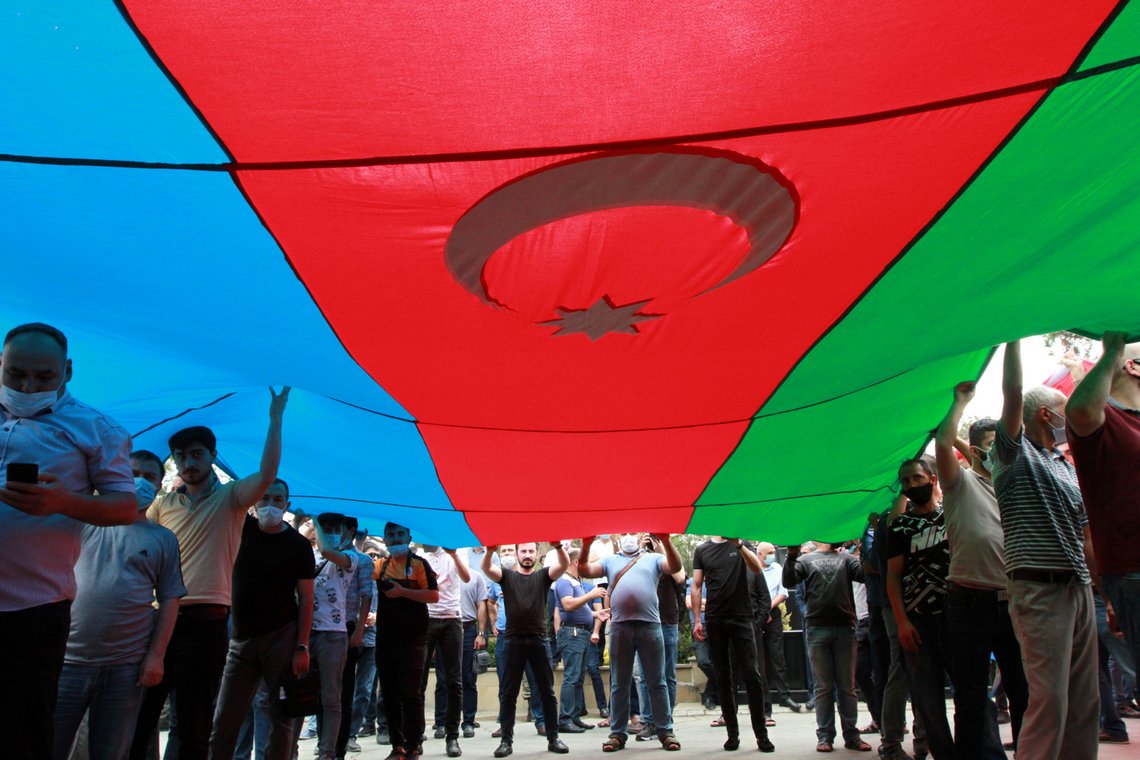 People hold the national flag during the funeral of Major General Polad Gashimov and Colonel Ilgar Mirzoyev of the Armed Forces of Azerbaijan, who were killed in armed clashes on the border between Azerbaijan and Armenia earlier this week, in Baku, Azerbaijan July 15, 2020. REUTERS/Vali Shukurov People hold the national flag during the funeral of Major General Polad Gashimov and Colonel Ilgar Mirzoyev of the Armed Forces of Azerbaijan, who were killed in armed clashes on the border between Azerbaijan and Armenia earlier this week, in Baku, Azerbaijan July 15, 2020. REUTERS/Vali Shukurov