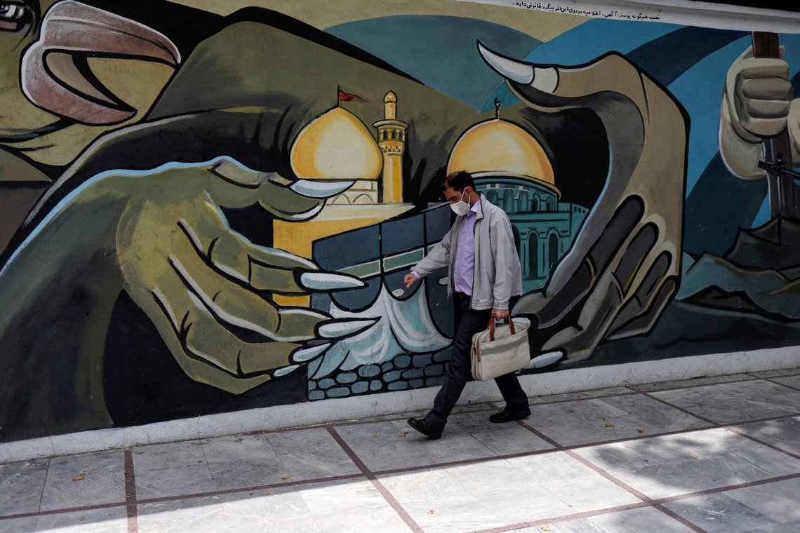 A man wearing a protective face mask walks past a Palestine mural on the wall following the outbreak of the coronavirus disease (COVID-19), in Tehran, Iran, April 30, 2020. WANA (West Asia News Agency)/Ali Khara via REUTERS ATTENTION EDITORS - THIS PICTURE WAS PROVIDED BY A THIRD PARTY A man wearing a protective face mask walks past a Palestine mural on the wall following the outbreak of the coronavirus disease (COVID-19), in Tehran, Iran, April 30, 2020. WANA (West Asia News Agency)/Ali Khara via REUTERS ATTENTION EDITORS - THIS PICTURE WAS PROVIDED BY A THIRD PARTY