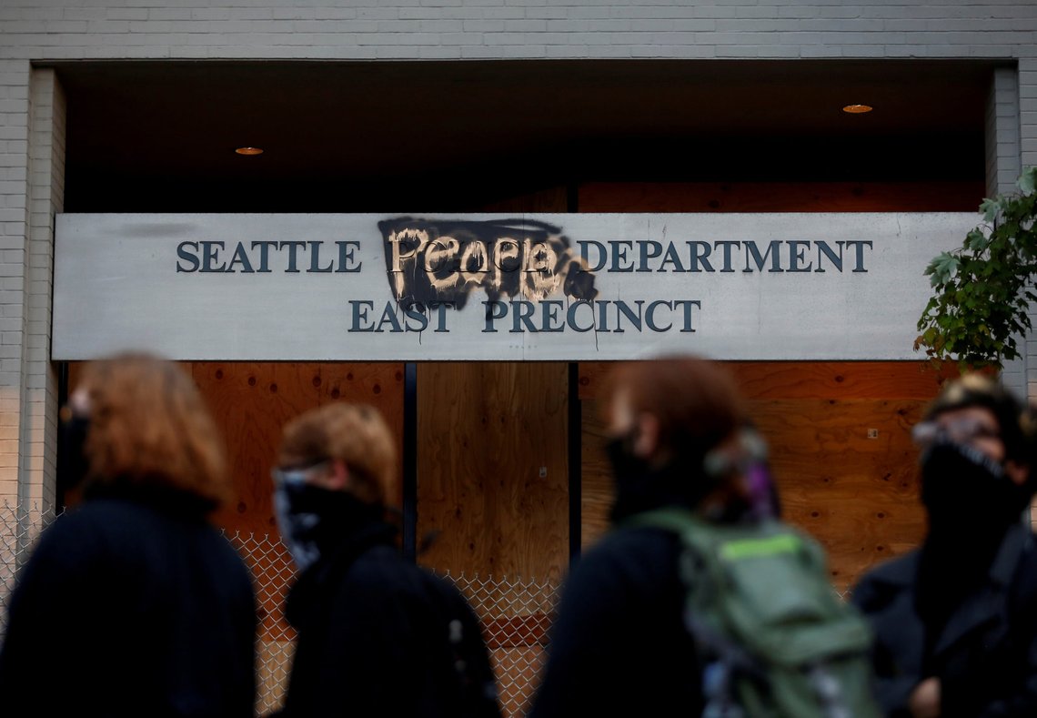 People stand in front of the Seattle Police Department's East Precinct sign, spray painted to replace "police" with "people" as the protesters established what they call an autonomous zone while continuing to demonstrate against racial inequality and call for defunding of Seattle police, in Seattle, Washington, U.S. June 9, 2020. Picture taken June 9, 2020. REUTERS/Lindsey Wasson TPX IMAGES OF THE DAY People stand in front of the Seattle Police Department's East Precinct sign, spray painted to replace "police" with "people" as the protesters established what they call an autonomous zone while continuing to demonstrate against racial inequality and call for defunding of Seattle police, in Seattle, Washington, U.S. June 9, 2020. Picture taken June 9, 2020. REUTERS/Lindsey Wasson TPX IMAGES OF THE DAY