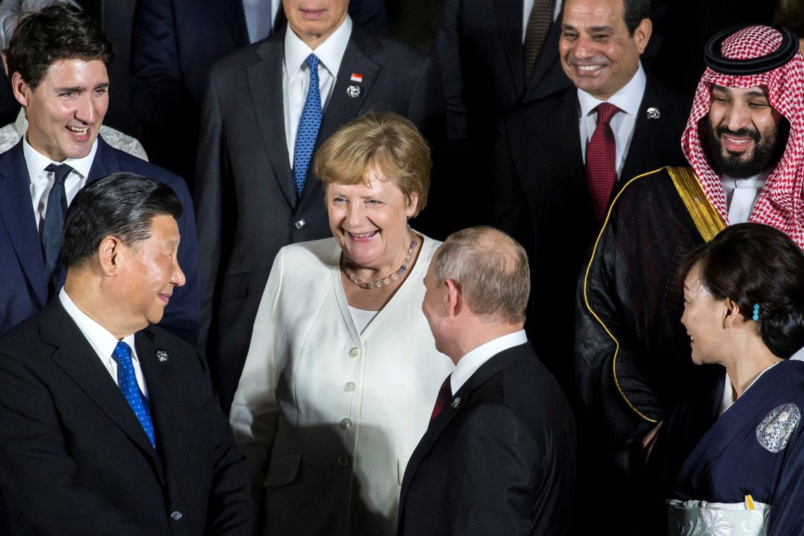 FILE PHOTO: Germany's Chancellor Angela Merkel speaks to China's President Xi Jinping and Russia's President Vladimir Putin during a family photo session in front of Osaka Castle at the G-20 summit, in Osaka, Japan June 28, 2019 Tomohiro Ohsumi/Pool via REUTERS/File Photo FILE PHOTO: Germany's Chancellor Angela Merkel speaks to China's President Xi Jinping and Russia's President Vladimir Putin during a family photo session in front of Osaka Castle at the G-20 summit, in Osaka, Japan June 28, 2019 Tomohiro Ohsumi/Pool via REUTERS/File Photo
