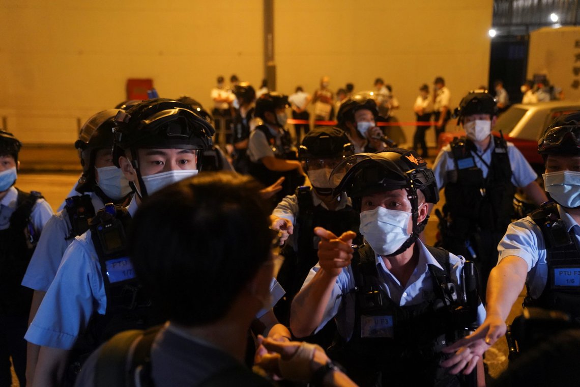 Riot police argue with journalists outside a police station where media mogul Jimmy Lai Chee-ying, founder of Apple Daily, was held after he was arrested by the national security unit in Hong Kong, China August 12, 2020. REUTERS/Lam Yik Riot police argue with journalists outside a police station where media mogul Jimmy Lai Chee-ying, founder of Apple Daily, was held after he was arrested by the national security unit in Hong Kong, China August 12, 2020. REUTERS/Lam Yik