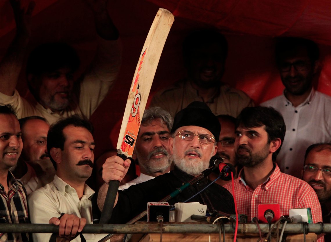 Tahir ul-Qadri, Sufi cleric and opposition leader of political party Pakistan Awami Tehreek (PAT), raises a cricket bat while addressing supporters in front of Parliament House during the Revolution March in Islamabad September 5, 2014. Weeks of mounting anti-government protests in Pakistan had been enough to convince five of the powerful army's 11 Corps Commanders that it was time for them to step in and force embattled Prime Minister Nawaz Sharif to resign. REUTERS/Akhtar Soomro (PAKISTAN - Tags: POLITICS CIVIL UNREST TPX IMAGES OF THE DAY SPORT CRICKET) Tahir ul-Qadri, Sufi cleric and opposition leader of political party Pakistan Awami Tehreek (PAT), raises a cricket bat while addressing supporters in front of Parliament House during the Revolution March in Islamabad September 5, 2014. Weeks of mounting anti-government protests in Pakistan had been enough to convince five of the powerful army's 11 Corps Commanders that it was time for them to step in and force embattled Prime Minister Nawaz Sharif to resign. REUTERS/Akhtar Soomro (PAKISTAN - Tags: POLITICS CIVIL UNREST TPX IMAGES OF THE DAY SPORT CRICKET)