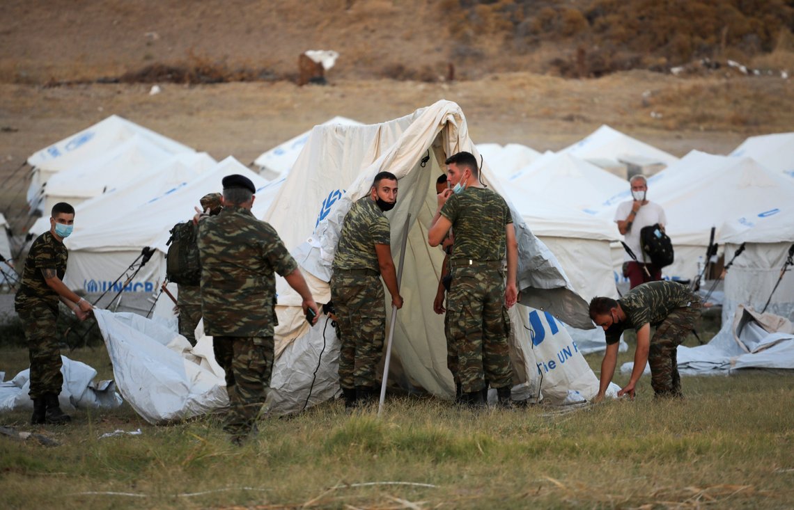 Greek soldiers set up tents at a disused shooting range to accommodate refugees and migrants from the destroyed Moria camp following a fire, on the island of Lesbos, Greece, September 11, 2020. REUTERS/Alkis Konstantinidis Greek soldiers set up tents at a disused shooting range to accommodate refugees and migrants from the destroyed Moria camp following a fire, on the island of Lesbos, Greece, September 11, 2020. REUTERS/Alkis Konstantinidis