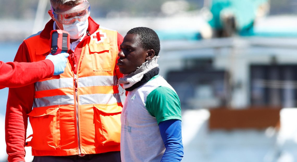 Red Cross members check the temperature of a migrant as he disembarks from a Spanish coast guard vessel in the port of Arguineguin on the island of Gran Canaria, Spain, May 19, 2020. REUTERS/Borja Suarez Red Cross members check the temperature of a migrant as he disembarks from a Spanish coast guard vessel in the port of Arguineguin on the island of Gran Canaria, Spain, May 19, 2020. REUTERS/Borja Suarez