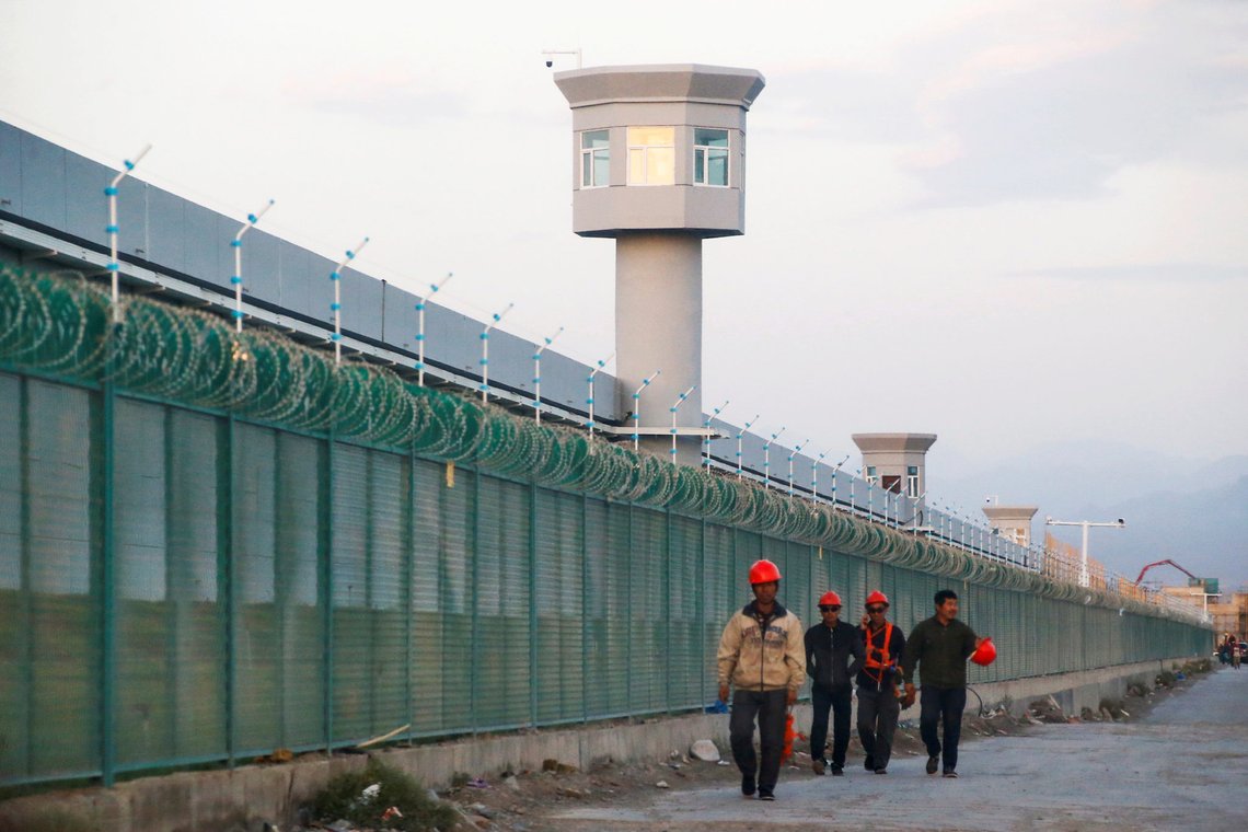FILE PHOTO: Workers walk by the perimeter fence of what is officially known as a vocational skills education centre in Dabancheng in Xinjiang Uighur Autonomous Region, China September 4, 2018. This centre, situated between regional capital Urumqi and tourist spot Turpan, is among the largest known ones, and was still undergoing extensive construction and expansion at the time the photo was taken. Picture taken September 4, 2018. REUTERS/Thomas Peter/File Photo FILE PHOTO: Workers walk by the perimeter fence of what is officially known as a vocational skills education centre in Dabancheng in Xinjiang Uighur Autonomous Region, China September 4, 2018. This centre, situated between regional capital Urumqi and tourist spot Turpan, is among the largest known ones, and was still undergoing extensive construction and expansion at the time the photo was taken. Picture taken September 4, 2018. REUTERS/Thomas Peter/File Photo