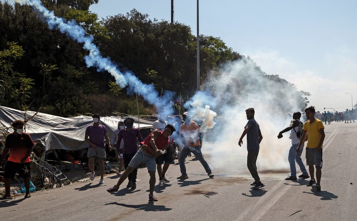 Refugees and migrants from the destroyed camp of Moria throw back tear gas fired by riot police during clashes, on the island of Lesbos, Greece, September 12, 2020. REUTERS/Alkis Konstantinidis Refugees and migrants from the destroyed camp of Moria throw back tear gas fired by riot police during clashes, on the island of Lesbos, Greece, September 12, 2020. REUTERS/Alkis Konstantinidis