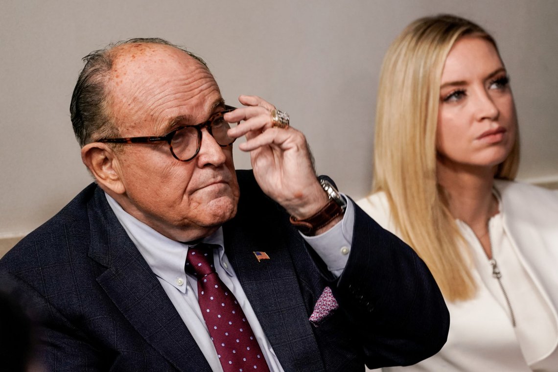 Rudy Giuliani, former New York City Mayor and personal attorney to U.S. President Donald Trump, listens next to White House press secretary Kayleigh McEnany as Trump speaks to reporters during a news conference inside the James S. Brady Briefing Room at the White House September 27, 2020 in Washington, U.S. REUTERS/Ken Cedeno NO RESALES. NO ARCHIVES. Rudy Giuliani, former New York City Mayor and personal attorney to U.S. President Donald Trump, listens next to White House press secretary Kayleigh McEnany as Trump speaks to reporters during a news conference inside the James S. Brady Briefing Room at the White House September 27, 2020 in Washington, U.S. REUTERS/Ken Cedeno NO RESALES. NO ARCHIVES.