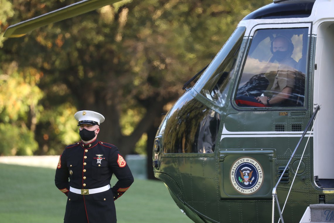 A U.S. Marine stands guard in front of the Marine One helicopter as he and a Marine pilot wait for U.S. President Donald Trump to depart the White House to fly to Walter Reed National Military Medical Center, where it was announced he will work for at least several days after testing positive for the coronavirus disease (COVID-19), on the South Lawn of the White House in Washington, U.S., October 2, 2020. REUTERS/Leah Millis A U.S. Marine stands guard in front of the Marine One helicopter as he and a Marine pilot wait for U.S. President Donald Trump to depart the White House to fly to Walter Reed National Military Medical Center, where it was announced he will work for at least several days after testing positive for the coronavirus disease (COVID-19), on the South Lawn of the White House in Washington, U.S., October 2, 2020. REUTERS/Leah Millis