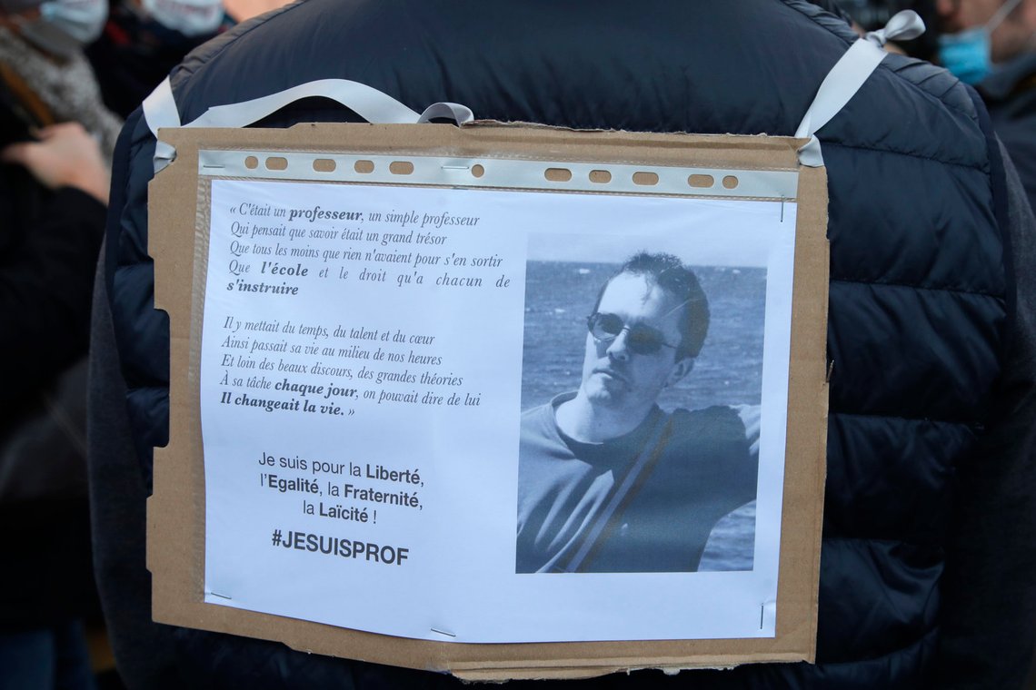 A demonstrator displays on his back a portrait of slain teacher Samuel Paty during a demonstration Sunday Oct. 18, 2020 in Paris. Demonstrations around France have been called in support of freedom of speech and to pay tribute to a French history teacher who was beheaded near Paris after discussing caricatures of Islam's Prophet Muhammad with his class. Samuel Paty was beheaded on Friday by a 18-year-old Moscow-born Chechen refugee who was shot dead by police. (AP Photo/Michel Euler) A demonstrator displays on his back a portrait of slain teacher Samuel Paty during a demonstration Sunday Oct. 18, 2020 in Paris. Demonstrations around France have been called in support of freedom of speech and to pay tribute to a French history teacher who was beheaded near Paris after discussing caricatures of Islam's Prophet Muhammad with his class. Samuel Paty was beheaded on Friday by a 18-year-old Moscow-born Chechen refugee who was shot dead by police. (AP Photo/Michel Euler)