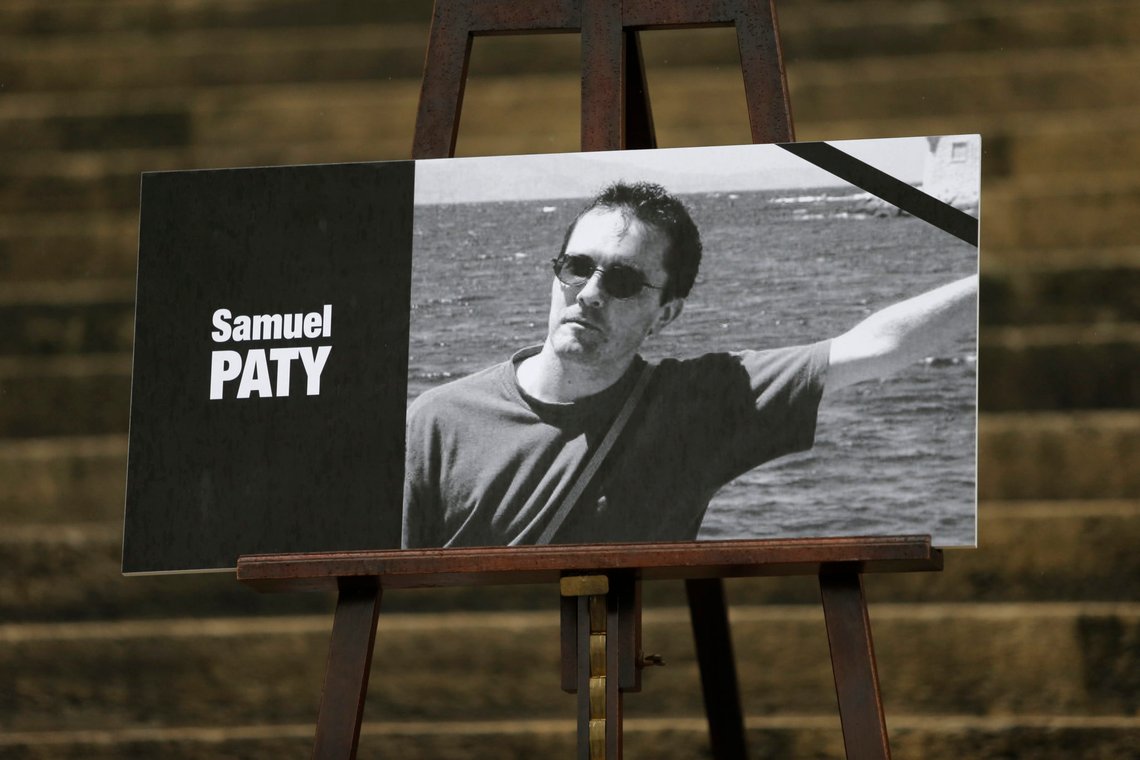 The portrait of slain teacher Samuel Paty with a black ribbon is displayed Tuesday, Oct.20, 2020 on the steps of the National Assembly in Paris. A memorial march will be held Tuesday evening near Paris in homage to the history teacher who was beheaded last week, while French police said 16 people remain in custody as part of the investigation into the attack. (AP Photo/Lewis Joly) The portrait of slain teacher Samuel Paty with a black ribbon is displayed Tuesday, Oct.20, 2020 on the steps of the National Assembly in Paris. A memorial march will be held Tuesday evening near Paris in homage to the history teacher who was beheaded last week, while French police said 16 people remain in custody as part of the investigation into the attack. (AP Photo/Lewis Joly)