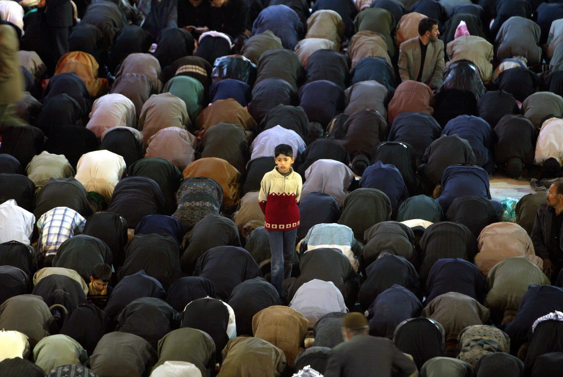A boy stands among a group of praying Shiite Muslims, inside the compound of the Imam Hussein shrine in recognition of the Ashoura holy days, in the the holy Shiite city of Karbala, Iraq, Sunday, Feb. 29, 2004. For the first time in decades this Tuesday, March 2, Iraqi Shiite Muslims will be free to gather at the Shiite holy city of Karbala for the climax of the Ashoura, the mourning of the death of one of their most important saints, Imam Hussein. (AP Photo/Brennan Linsley) A boy stands among a group of praying Shiite Muslims, inside the compound of the Imam Hussein shrine in recognition of the Ashoura holy days, in the the holy Shiite city of Karbala, Iraq, Sunday, Feb. 29, 2004. For the first time in decades this Tuesday, March 2, Iraqi Shiite Muslims will be free to gather at the Shiite holy city of Karbala for the climax of the Ashoura, the mourning of the death of one of their most important saints, Imam Hussein. (AP Photo/Brennan Linsley)