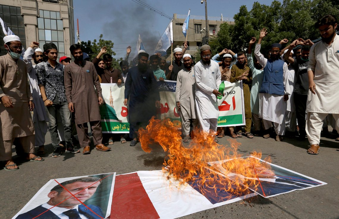 Supporters of the Muslims Students Organization burn a representation of a French national flag and defaced images of French President Emmanuel Macron during a protest against the president and against the publishing of caricatures of the Prophet Muhammad they deem blasphemous in Karachi, Pakistan, Friday, Oct. 30, 2020. Muslims have been calling for both protests and a boycott of French goods in response to France's stance on caricatures of Islam's most revered prophet. (AP Photo/Fareed Khan) Supporters of the Muslims Students Organization burn a representation of a French national flag and defaced images of French President Emmanuel Macron during a protest against the president and against the publishing of caricatures of the Prophet Muhammad they deem blasphemous in Karachi, Pakistan, Friday, Oct. 30, 2020. Muslims have been calling for both protests and a boycott of French goods in response to France's stance on caricatures of Islam's most revered prophet. (AP Photo/Fareed Khan)