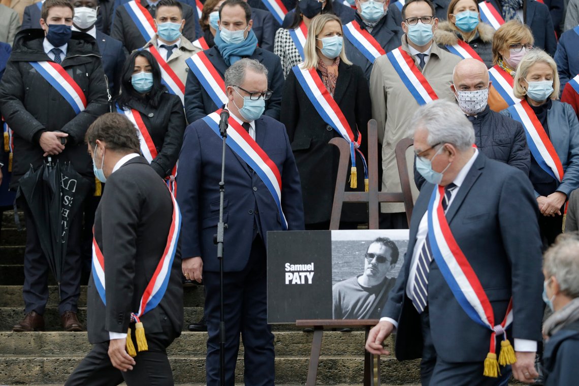 French lawmakers gather to pay homage to slain teacher Samuel Paty, Tuesday, Oct. 20, 2020 on the steps of the National Assembly in Paris. A memorial march will be held Tuesday evening near Paris in homage to the history teacher who was beheaded last week, while French police said 16 people remain in custody as part of the investigation into the attack. (AP Photo/Lewis Joly) French lawmakers gather to pay homage to slain teacher Samuel Paty, Tuesday, Oct. 20, 2020 on the steps of the National Assembly in Paris. A memorial march will be held Tuesday evening near Paris in homage to the history teacher who was beheaded last week, while French police said 16 people remain in custody as part of the investigation into the attack. (AP Photo/Lewis Joly)