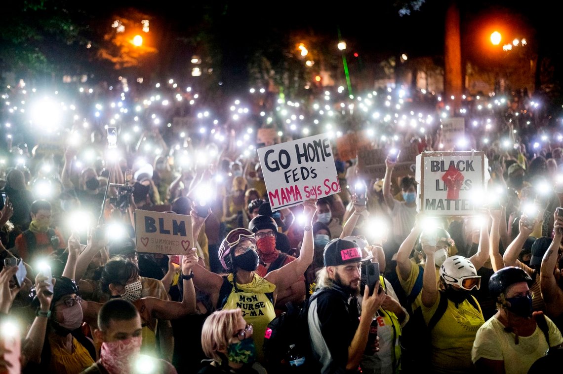 FILE - In this July 20, 2020, file photo, hundreds of protesters hold their phones aloft in Portland, Ore. The cities of Oakland and Portland sued the U.S. Department of Homeland Security and the Justice Department on Thursday, Oct. 15, 2020, alleging that the agencies are overstepping constitutional limits in their use of federal law enforcement officers to tamp down on protests. (AP Photo/Noah Berger, File) FILE - In this July 20, 2020, file photo, hundreds of protesters hold their phones aloft in Portland, Ore. The cities of Oakland and Portland sued the U.S. Department of Homeland Security and the Justice Department on Thursday, Oct. 15, 2020, alleging that the agencies are overstepping constitutional limits in their use of federal law enforcement officers to tamp down on protests. (AP Photo/Noah Berger, File)