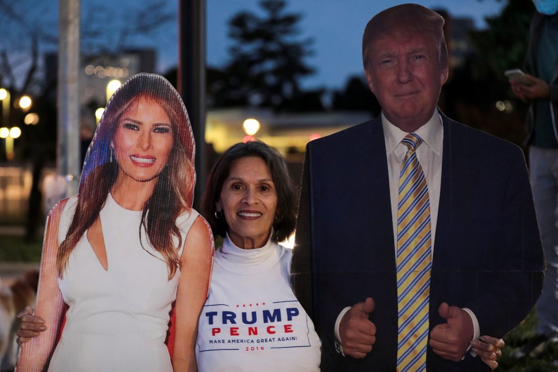 A supporter stands in between cardboard cutouts of First Lady Melania Trump and U.S. President Donald Trump, outside of the Walter Reed National Military Medical Center, where President Trump is being treated for the coronavirus disease (COVID-19) in Bethesda, Maryland, U.S. October 4, 2020. REUTERS/Cheriss May A supporter stands in between cardboard cutouts of First Lady Melania Trump and U.S. President Donald Trump, outside of the Walter Reed National Military Medical Center, where President Trump is being treated for the coronavirus disease (COVID-19) in Bethesda, Maryland, U.S. October 4, 2020. REUTERS/Cheriss May