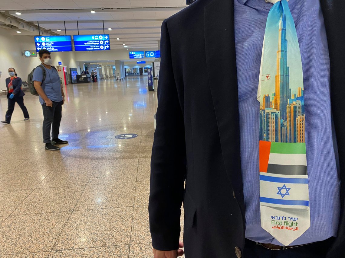 An Israeli tourist wears a souvenir tie with a first flight sign and the flags of Israel and the UAE after landing at Dubai Airport, in the United Arab Emirates, Sunday, Nov. 8, 2020. The first flight carrying Israeli tourists to the UAE landed Sunday in the city-state of Dubai, the latest sign of the normalization deal reached between the two nations. (AP Photo/Malak Harb) An Israeli tourist wears a souvenir tie with a first flight sign and the flags of Israel and the UAE after landing at Dubai Airport, in the United Arab Emirates, Sunday, Nov. 8, 2020. The first flight carrying Israeli tourists to the UAE landed Sunday in the city-state of Dubai, the latest sign of the normalization deal reached between the two nations. (AP Photo/Malak Harb)