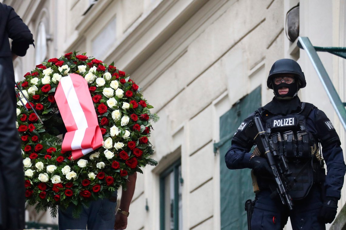 A man carries a wreath as he walks past a police officer in Vienna, Austria, Tuesday, Nov. 3, 2020. Police in the Austrian capital said several shots were fired shortly after 8 p.m. local time on Monday, Nov. 2, in a lively street in the city center of Vienna. Austria's top security official said authorities believe there were several gunmen involved and that a police operation was still ongoing. (AP Photo/Matthias Schrader) A man carries a wreath as he walks past a police officer in Vienna, Austria, Tuesday, Nov. 3, 2020. Police in the Austrian capital said several shots were fired shortly after 8 p.m. local time on Monday, Nov. 2, in a lively street in the city center of Vienna. Austria's top security official said authorities believe there were several gunmen involved and that a police operation was still ongoing. (AP Photo/Matthias Schrader)