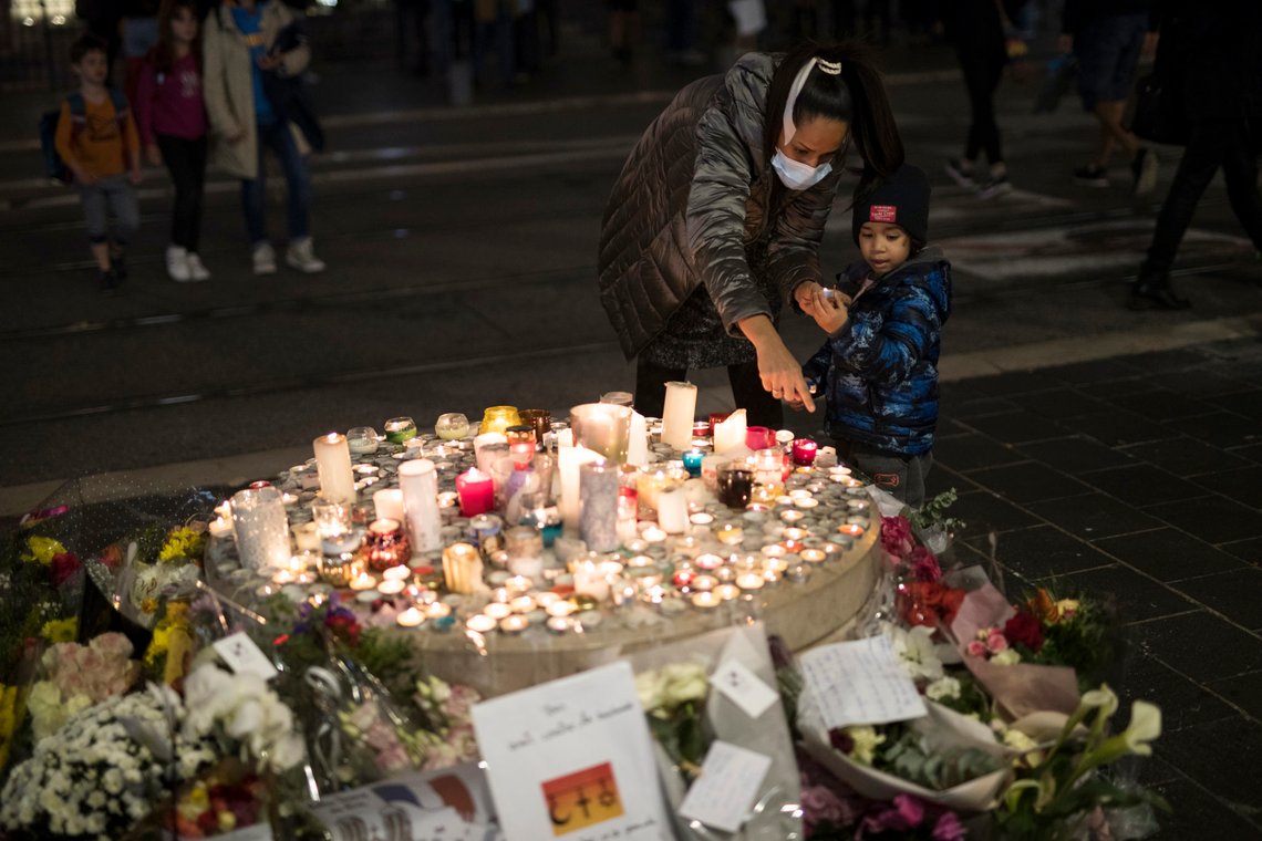 A family lights a candle in front of the Notre Dame church in Nice, France, Friday, Oct. 30, 2020. A new suspect is in custody in the investigation into a gruesome attack by a Tunisian man who killed three people in a French church. France heightened its security alert amid religious and geopolitical tensions around cartoons mocking the Muslim prophet. (AP Photo/Daniel Cole) A family lights a candle in front of the Notre Dame church in Nice, France, Friday, Oct. 30, 2020. A new suspect is in custody in the investigation into a gruesome attack by a Tunisian man who killed three people in a French church. France heightened its security alert amid religious and geopolitical tensions around cartoons mocking the Muslim prophet. (AP Photo/Daniel Cole)
