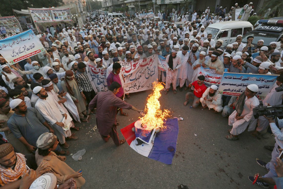 Supporters of a religious group burn defaced images of French President Emmanuel Macron with a representation of a French flag during a protest against the French president and republishing of caricatures of the Prophet Muhammad they deem blasphemous, in Karachi, Pakistan, Saturday, Oct. 31, 2020. Muslims have been calling for both protests and a boycott of French goods in response to France's stance on caricatures of Islam's most revered prophet. (AP Photo/Fareed Khan) Supporters of a religious group burn defaced images of French President Emmanuel Macron with a representation of a French flag during a protest against the French president and republishing of caricatures of the Prophet Muhammad they deem blasphemous, in Karachi, Pakistan, Saturday, Oct. 31, 2020. Muslims have been calling for both protests and a boycott of French goods in response to France's stance on caricatures of Islam's most revered prophet. (AP Photo/Fareed Khan)
