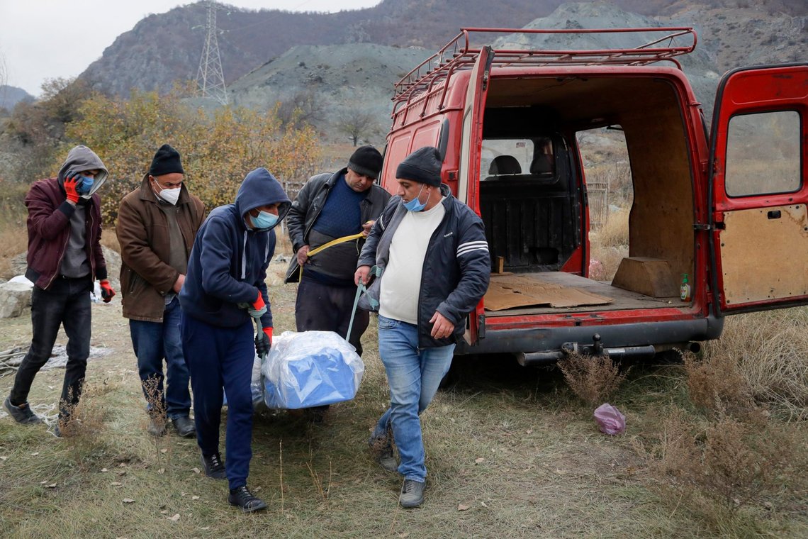 Ethnic Armenians carry a coffin with the body of their relative Sergei Gabrilyan, moved from a grave, to repatriate his remains to Armenia, in Kalbajar in separatist region of Nagorno-Karabakh, Monday, Nov. 16, 2020. It is unclear when any civilians might try to settle in Karvachar, which will now be known by its Azeri name Kalbajar, or elsewhere. Armenians who are going to leave separatist region of Nagorno-Karabakh dig up the remains of their ancestors to bring them from the territory, which is to be handed over to Azerbaijanis. (AP Photo/Sergei Grits) Ethnic Armenians carry a coffin with the body of their relative Sergei Gabrilyan, moved from a grave, to repatriate his remains to Armenia, in Kalbajar in separatist region of Nagorno-Karabakh, Monday, Nov. 16, 2020. It is unclear when any civilians might try to settle in Karvachar, which will now be known by its Azeri name Kalbajar, or elsewhere. Armenians who are going to leave separatist region of Nagorno-Karabakh dig up the remains of their ancestors to bring them from the territory, which is to be handed over to Azerbaijanis. (AP Photo/Sergei Grits)