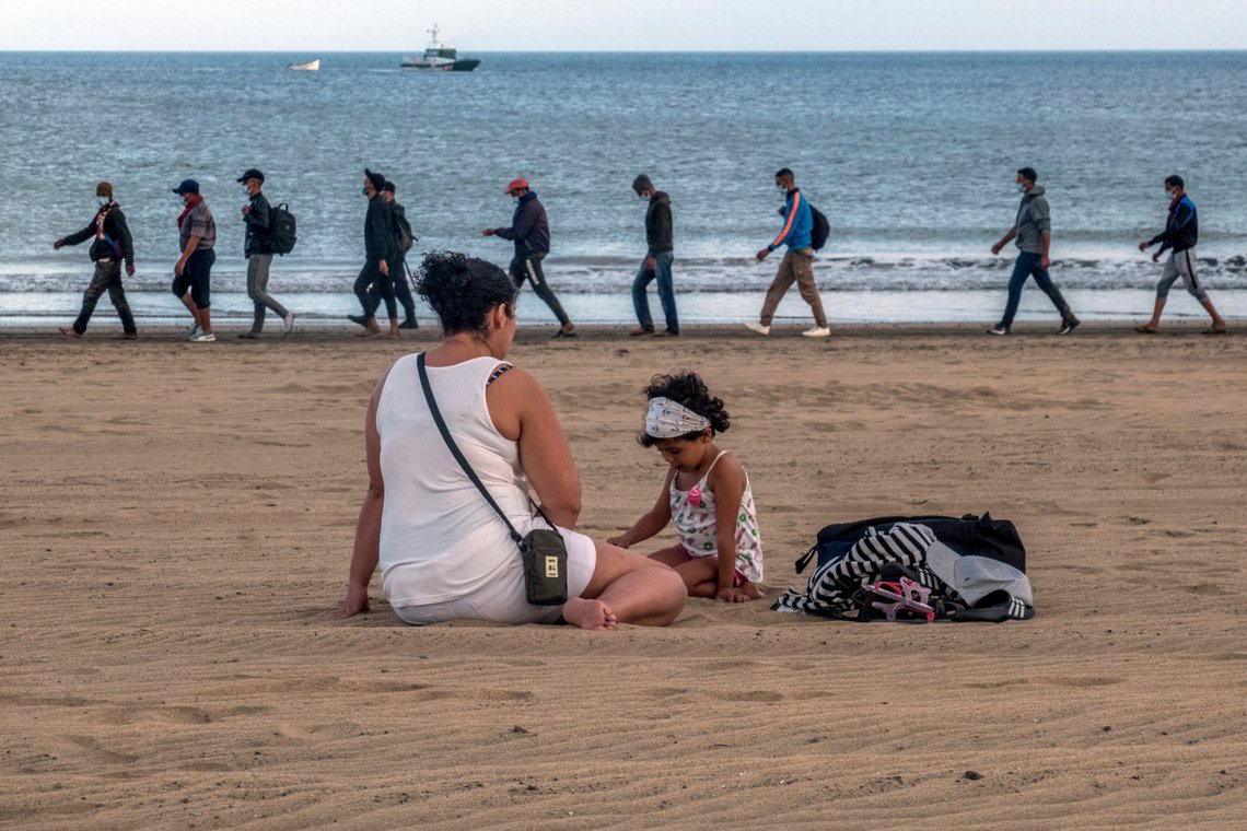 FILE - In this Tuesday, Oct.20, 2020 file photo, migrants from Morocco walk along the shore escorted by Spanish Police after arriving at the coast of the Canary Island, Spain. Overwhelmed authorities on the Canary Islands are on Wednesday, Nov. 11 asking Spains government for help to care for a rising number of migrants arriving from west Africa. Nearly 2,000 migrants are living in the facility designed to shelter 400 people on a pier on the island of Gran Canaria. (AP Photo/Javier Bauluz) FILE - In this Tuesday, Oct.20, 2020 file photo, migrants from Morocco walk along the shore escorted by Spanish Police after arriving at the coast of the Canary Island, Spain. Overwhelmed authorities on the Canary Islands are on Wednesday, Nov. 11 asking Spains government for help to care for a rising number of migrants arriving from west Africa. Nearly 2,000 migrants are living in the facility designed to shelter 400 people on a pier on the island of Gran Canaria. (AP Photo/Javier Bauluz)