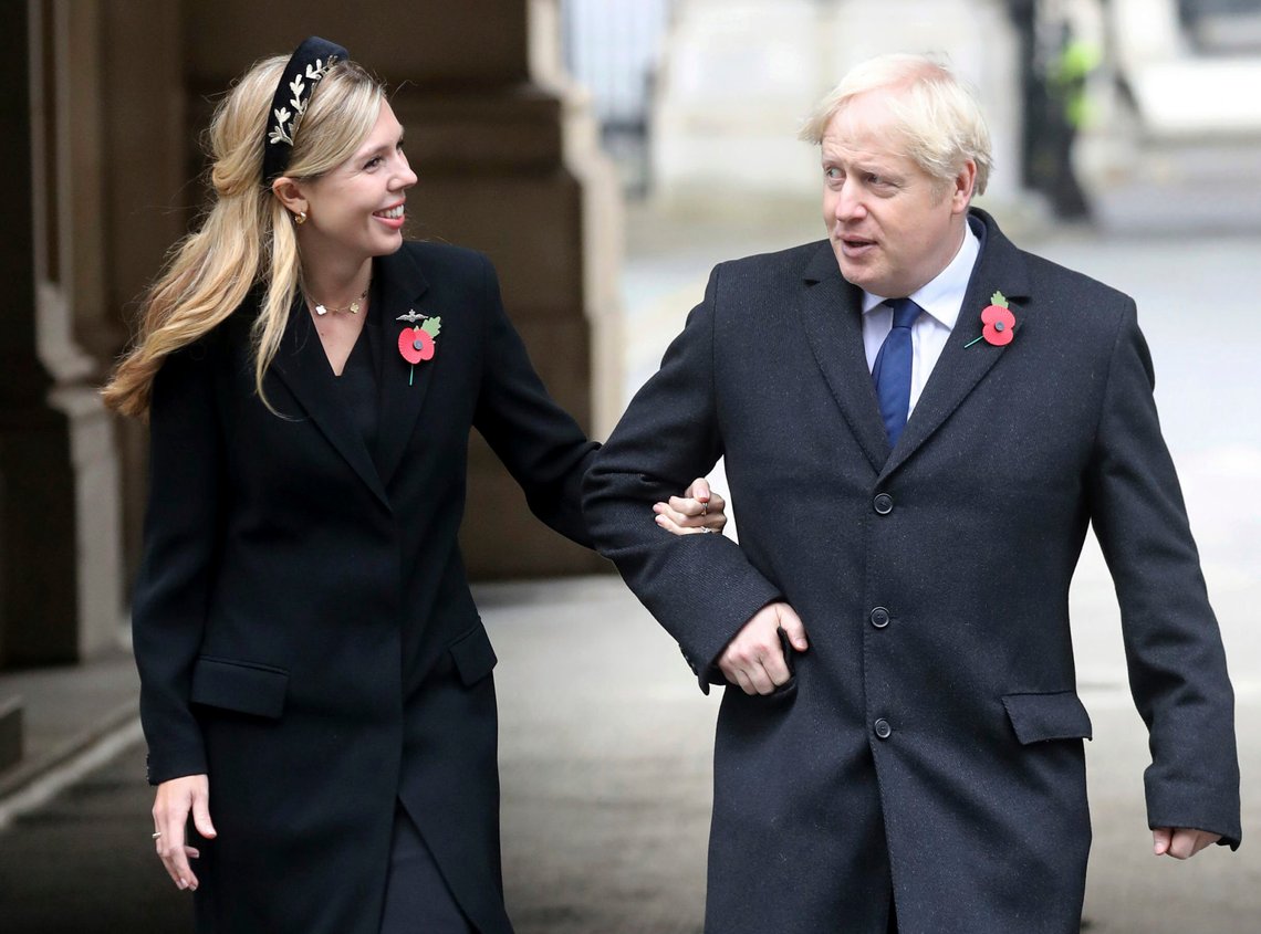 Britain's Prime Minister Boris Johnson, right, with partner Carrie Symonds, on their way to meet veterans after the Remembrance Sunday service at the Cenotaph, in Whitehall, London, Sunday Nov. 8, 2020. (Chris Jackson/Pool Photo via AP) Britain's Prime Minister Boris Johnson, right, with partner Carrie Symonds, on their way to meet veterans after the Remembrance Sunday service at the Cenotaph, in Whitehall, London, Sunday Nov. 8, 2020. (Chris Jackson/Pool Photo via AP)