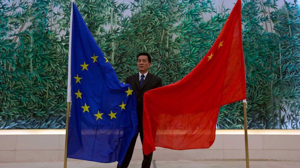 A Chinese Trade Ministry officer prepares the EU and Chinese flags prior to a joint reading of statements by EU Trade Commissioner Karel De Gucht and Chinese Commerce Minister Gao Hucheng, unseen, at the Chinese Ministry of Commerce in Beijing, China, Friday, June 21, 2013. (AP Photo/Ng Han Guan) A Chinese Trade Ministry officer prepares the EU and Chinese flags prior to a joint reading of statements by EU Trade Commissioner Karel De Gucht and Chinese Commerce Minister Gao Hucheng, unseen, at the Chinese Ministry of Commerce in Beijing, China, Friday, June 21, 2013. (AP Photo/Ng Han Guan)