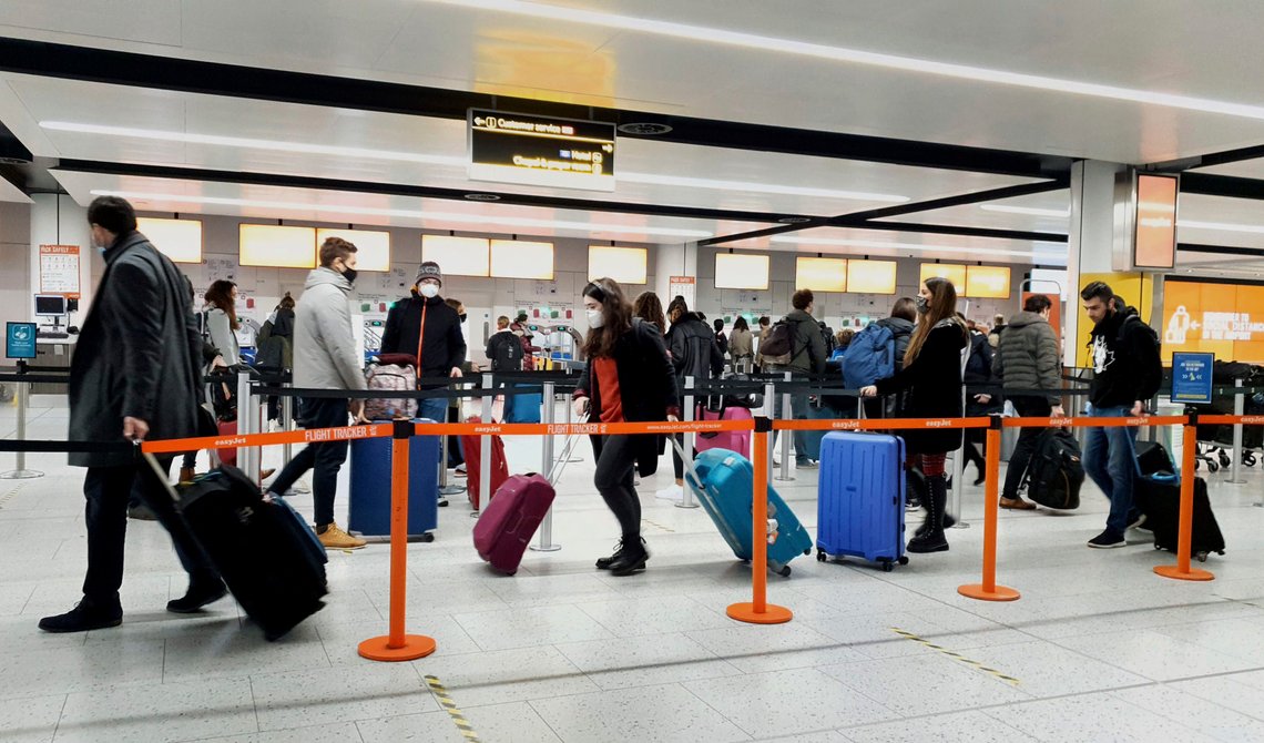 FILE - In this Dec. 20, 2020, file photo, passengers queue for check-in at Gatwick Airport in West Sussex, England, south of London. The United States will require airline passengers from Britain to get a negative COVID-19 test before their flight, the Centers for Disease Control and Prevention announced late Thursday, Dec. 24. The U.S. is the latest country to announce new travel restrictions because of a new variant of the coronavirus that is spreading in Britain. (Gareth Fuller/PA via AP) FILE - In this Dec. 20, 2020, file photo, passengers queue for check-in at Gatwick Airport in West Sussex, England, south of London. The United States will require airline passengers from Britain to get a negative COVID-19 test before their flight, the Centers for Disease Control and Prevention announced late Thursday, Dec. 24. The U.S. is the latest country to announce new travel restrictions because of a new variant of the coronavirus that is spreading in Britain. (Gareth Fuller/PA via AP)