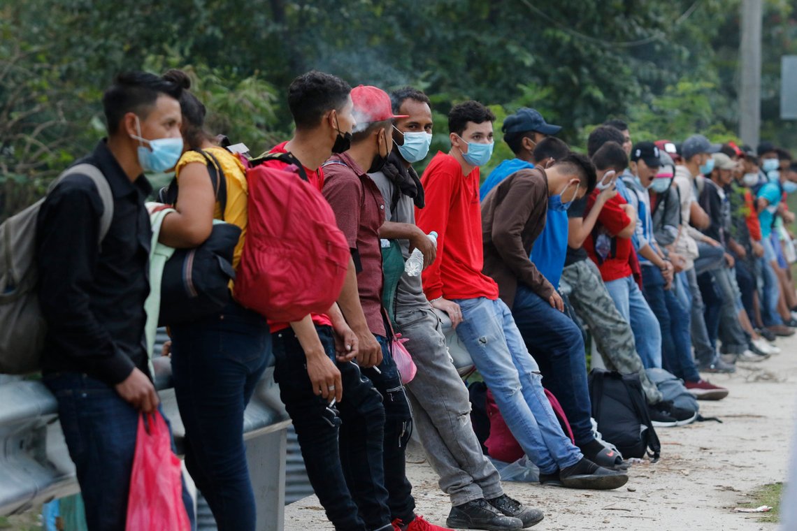 Migrants trying to reach the U.S. border rest at the edge of a highway as they await rides on passing vehicles, near Choloma, Honduras, Thursday, Jan. 14, 2021. About 200 Honduran migrants resumed walking toward the border with Guatemala early Thursday, a day before a migrant caravan was scheduled to depart the city of San Pedro Sula. (AP Photo/Delmer Martinez) Migrants trying to reach the U.S. border rest at the edge of a highway as they await rides on passing vehicles, near Choloma, Honduras, Thursday, Jan. 14, 2021. About 200 Honduran migrants resumed walking toward the border with Guatemala early Thursday, a day before a migrant caravan was scheduled to depart the city of San Pedro Sula. (AP Photo/Delmer Martinez)